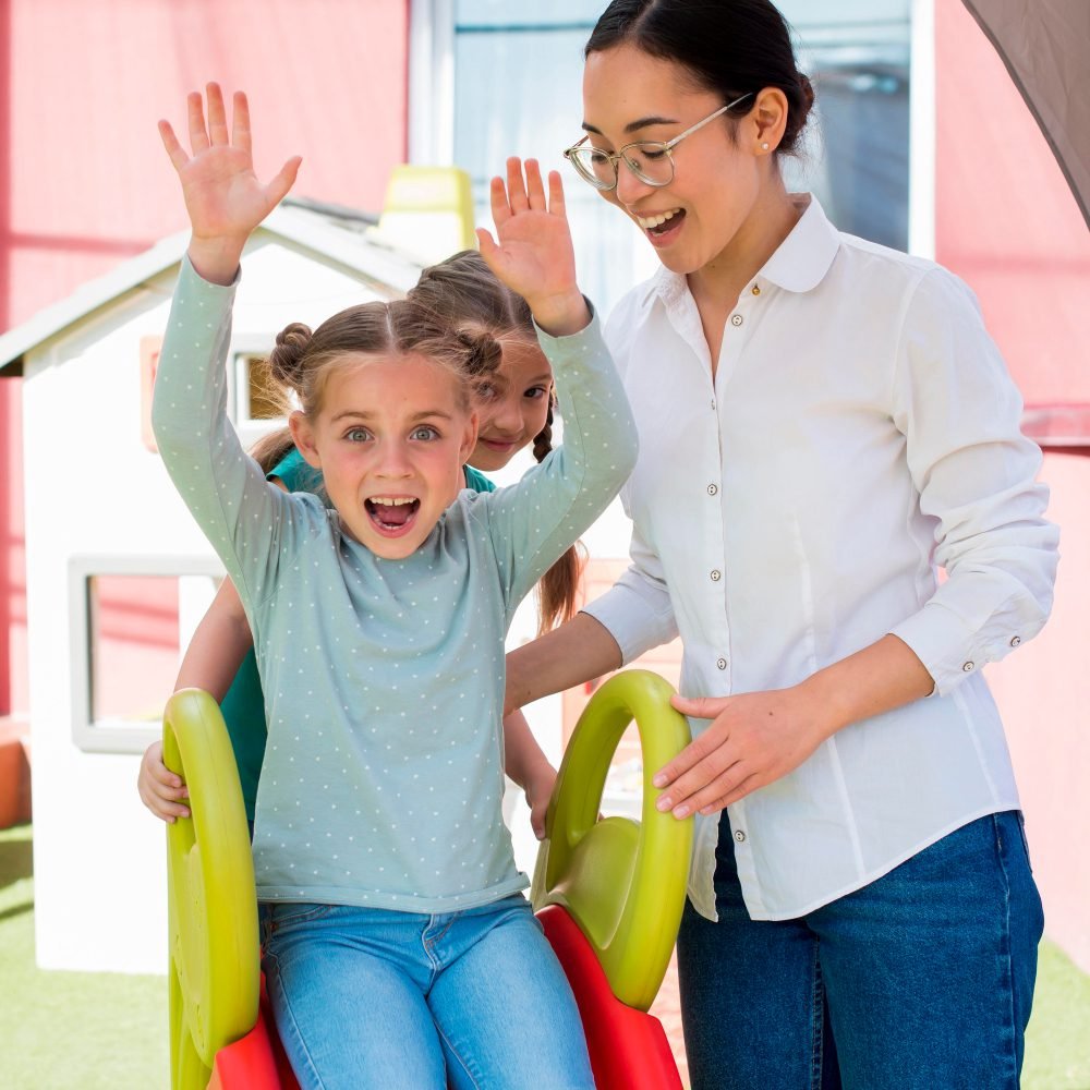 Home 19 Child playing on a playground slide with a support worker
